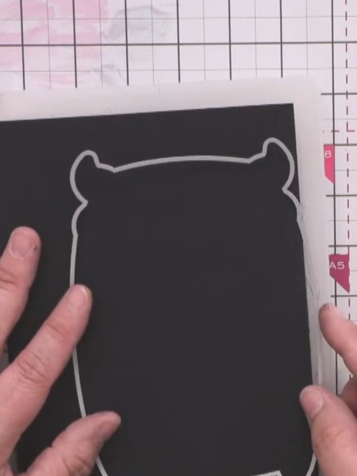 Step 1: Fold a blank black card in half to create a deep crease. Position the monster die over the card so it overhang