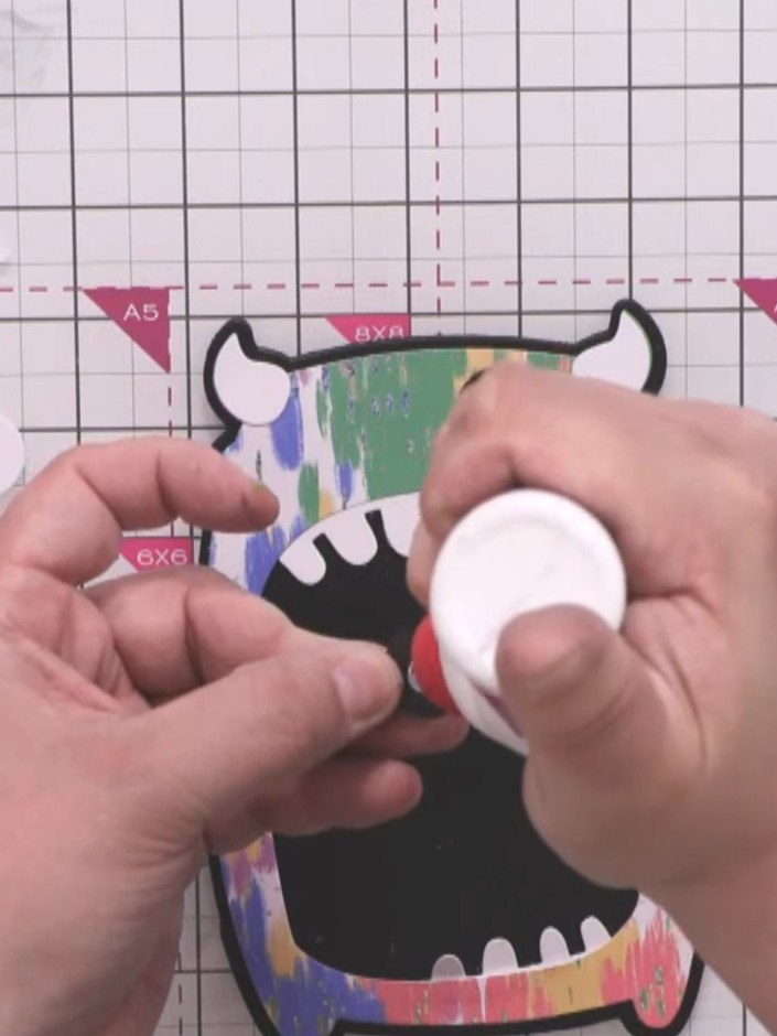 Step 9: Glue the white eye pieces onto the black circle, positioning them at different heights and angles to create a 