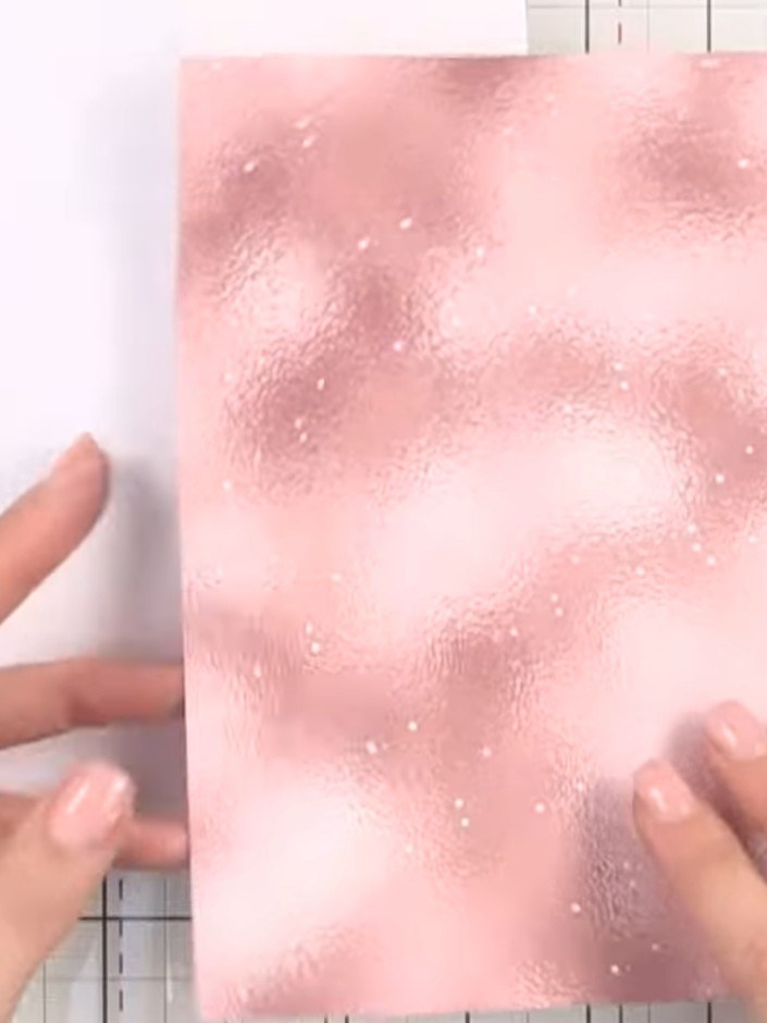 Step 1: Create a top-folding card base using the hammered all surfaces sparkle paper in pink. Position the sparkle pap