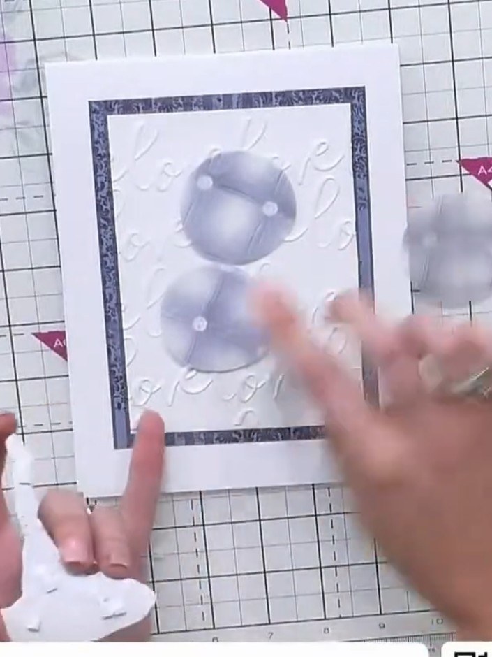 Step 8: Attach the punched vellum circles around the embossed design using adhesive. Position them to add elegance and