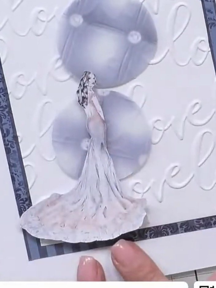 Step 9: Position the fussy-cut lady image on the lower edge of the card, next to the sentiment tag, to create visual b
