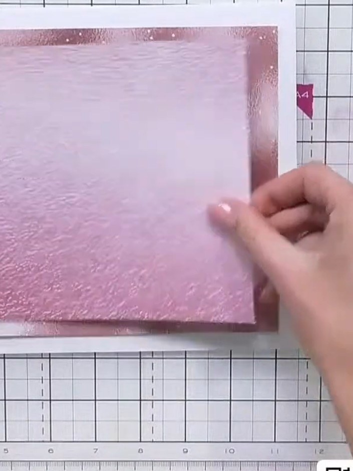 Step 1: Select a piece of pink textured foundation paper with a mirrored appearance from the paper pad. Remove the pro
