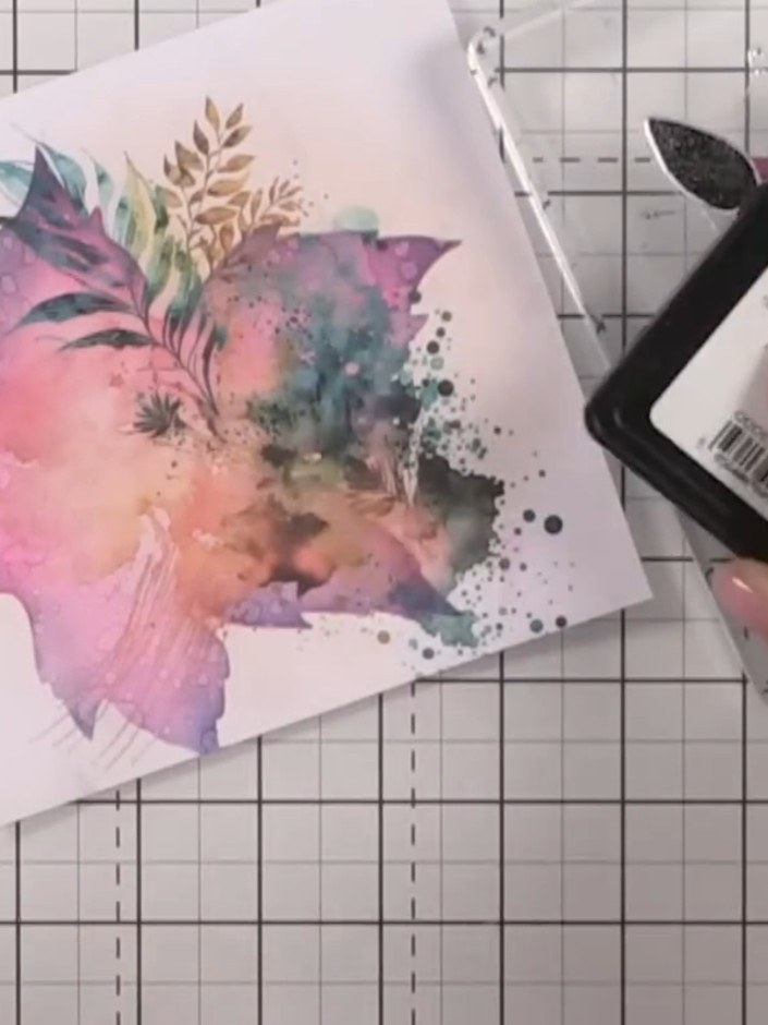 Step 8: Ink the solid lamination flower stamp in black ink and stamp it off the edge of the watercolour design to add 